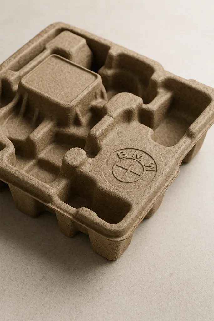 Recycled paper moulded pulp tray designed for automotive components, showcasing thermoformed packaging with precise contours and sustainable materials.